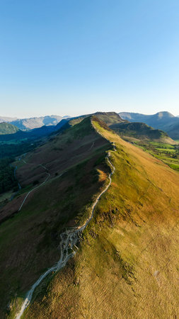 Aerial vertical landscape of the walking path along the top of Catbells mountain ridge in the English Lake District National Park with Manesty woods and Newlands valleyの写真素材