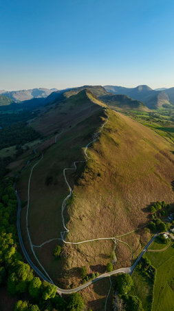 Aerial vertical landscape of the walking path along the top of Catbells mountain ridge in the English Lake District National Park with Manesty woods and Newlands valleyの写真素材