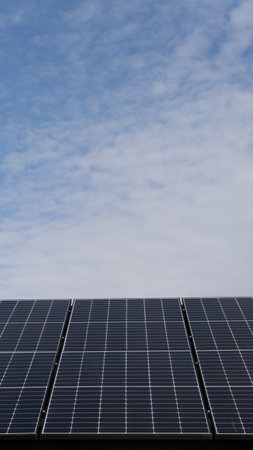 Low angle close up view of photovoltaic solar panels generating renewable energy and electricity for domestic homes and business with copy space aboveの写真素材