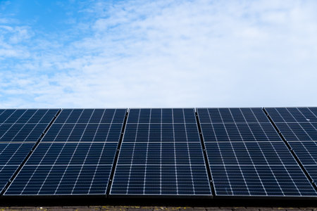 Low angle close up view of photovoltaic solar panels generating renewable energy and electricity for domestic homes and business with copy space aboveの写真素材