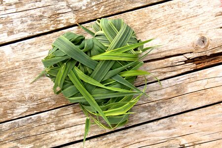Heart shaped from green grass on wooden backgroundの写真素材