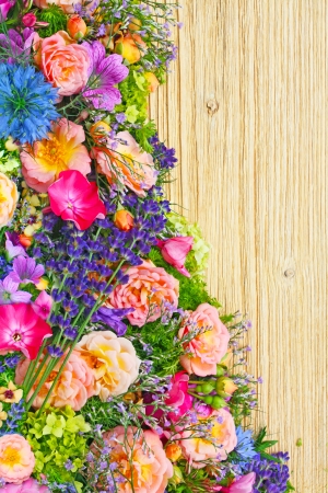 border made with fresh summer flowers on wooden backgroundの写真素材