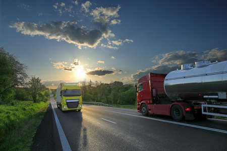 Landscape with a moving truck on the highway at sunset.の写真素材