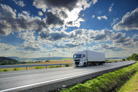 Landscape with a moving truck on the highway at sunset.の写真素材