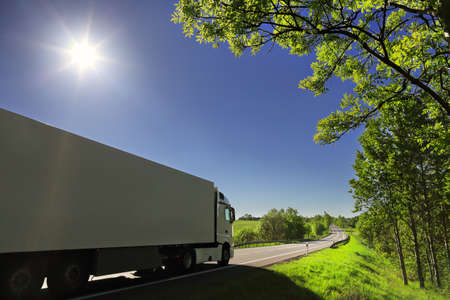 Landscape with a moving truck on the highway at sunset.の写真素材