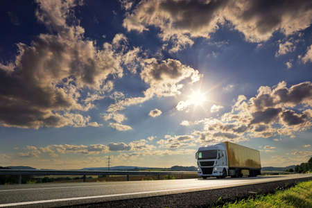 Landscape with a moving truck on the highway at sunset.の写真素材