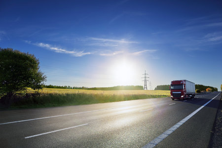 Landscape with a moving truck on the highway at sunset.の写真素材