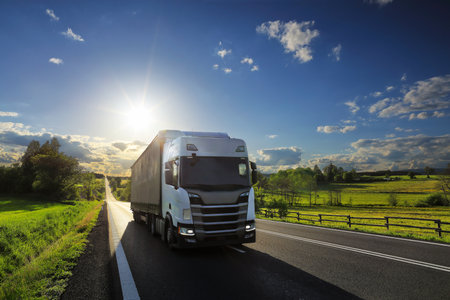 Landscape with a moving truck on the highway at sunset.の写真素材