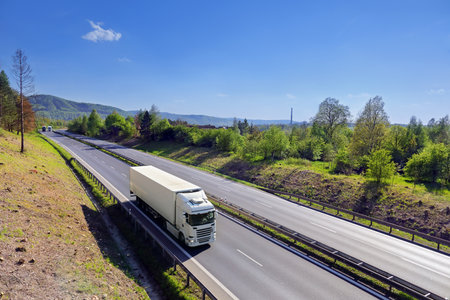 Landscape with a moving truck on the highway at sunset.の写真素材