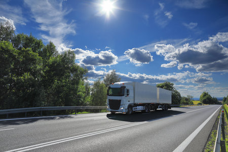 Truck on the highway under blue sky with white clouds. Transportation and logisticsの写真素材