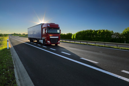 Truck on the highway at sunset. Freight transportation concept.の写真素材
