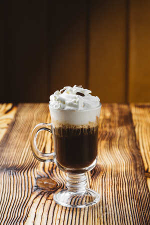 Irish coffee in glass on wooden tableの写真素材