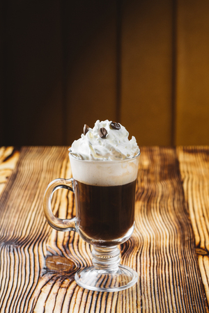Irish coffee in glass on wooden tableの写真素材