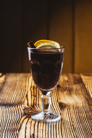 Mulled red wine with spices and oranges on a wooden rustic tableの写真素材