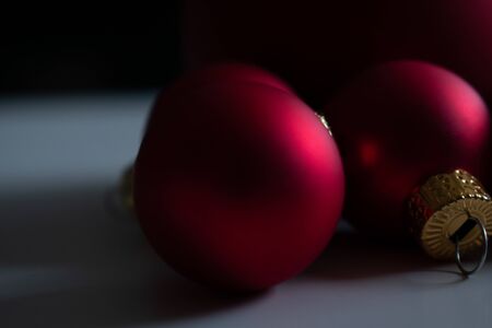close up of some red christmas balls on a white deskの写真素材
