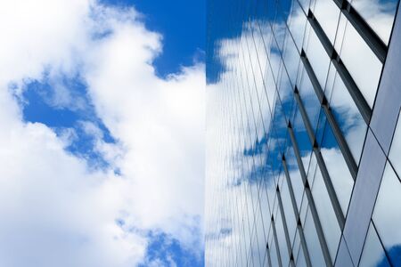 Office building details reflecting blue sky and clouds in windows