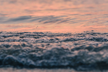 Closeup waves reflecting sunset light