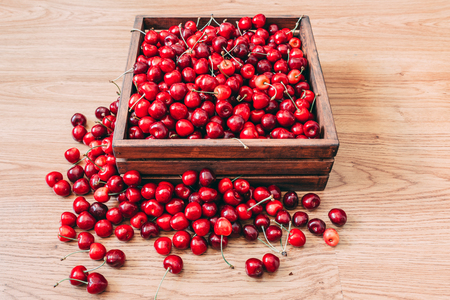 Sweet cherries in the wooden box on the wooden tableの写真素材
