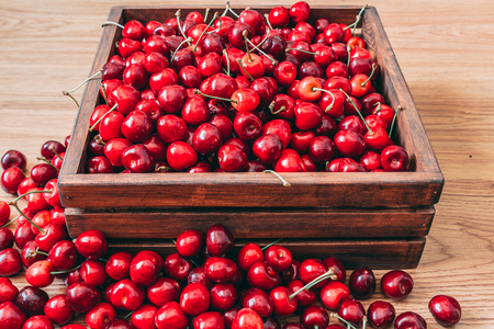 Sweet cherries in the wooden box on the wooden tableの写真素材