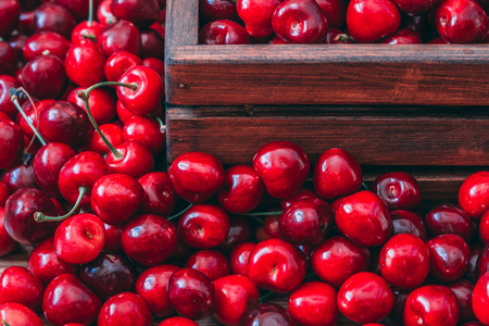 Sweet cherries in the wooden box on the wooden tableの写真素材