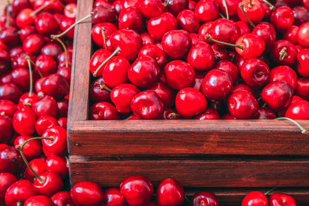 Sweet cherries in the wooden box on the wooden tableの写真素材
