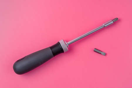 Black screwdriver with replaceable tip on the pink backgroundの写真素材