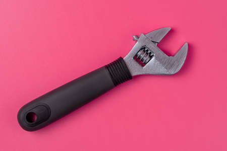 Adjustable wrench with black handle isolated on pink backgroundの写真素材