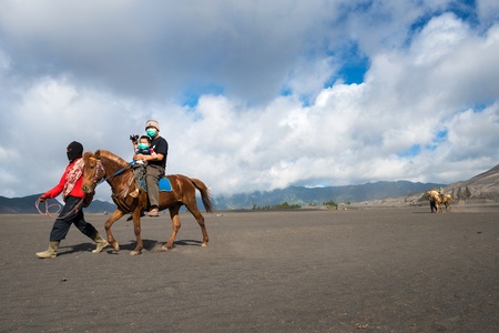 EAST JAVA,INDONESIA-MAY 05 : Tourists ride the horse at Mount Bromo, The active Mount Bromo is one of the most visited tourist attractions and part of the Tengger massif on May 05,2013 in East Java, Indonesia.のeditorial素材