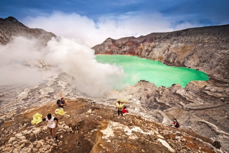 EAST JAVA,INDONESIA-DEC 11 Unidentified miner harvests raw sulphur from the crater of Kawah Ijen volcano in hazardous working environment with minimal protection n Kawah Ijen on Dec 11,2010 East Java, Indonesiaのeditorial素材