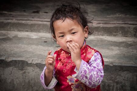 GANGTOK, SIKKIM, INDIA - AUG 19: Young unidentified indian girl, playing on the street on August 19, 2012 in Gungtok, Sikkim, Indiaのeditorial素材