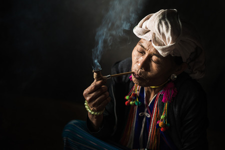 CHIANG MAI, THAILAND - JUL 25 : Karen hill tribe is smoking tobacco pipe with traditional clothes...