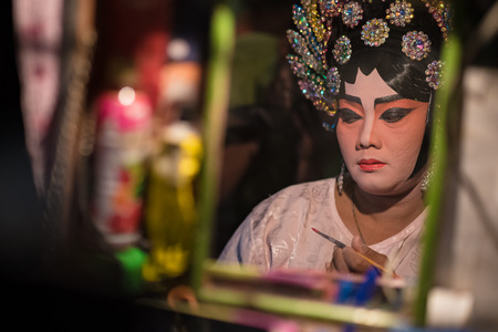 BANGKOK - OCTOBER 16: A Chinese opera actress painting mask on her face before the performance at backstage at major shrine in Bangkok's chinatown on October 16, 2015 in Bangkok,Thailandのeditorial素材