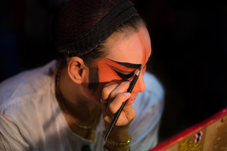 BANGKOK - OCTOBER 16: A Chinese opera actress painting mask on her face before the performance at backstage at major shrine in Bangkok's chinatown on October 16, 2015 in Bangkok,Thailandのeditorial素材