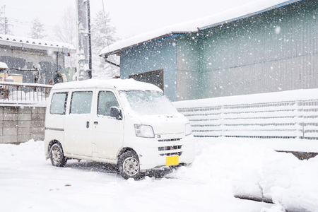 Fresh white snow falling at public park cover road and car in winter season at Kawaguchiko,Japan.の写真素材