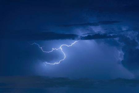 Thunder storm lightning strike on the dark cloudy sky background at night.の写真素材