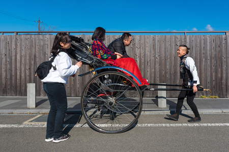 KYOTO,JAPAN-NOV26:Unidentified tourists on Japanese traditional rickshaw for sightseeing around Arashiyama in Kyoto on November 26,2106.Arashiyama is a one of attraction landmark for tourists.のeditorial素材