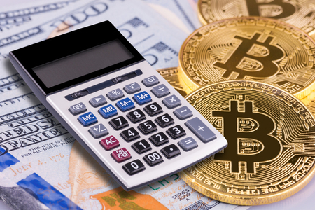 Financial calculator on Bitcoin and US Dollar bank background.Conceptual design for technology of Cryptocurrency and money investing.の写真素材