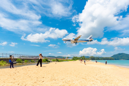 PHUKET,THAILAND-MAY05:Unidentified tourists at Mai Khao beach with commercial aircraft landing at Phuket International Airport on May 5,2108.のeditorial素材