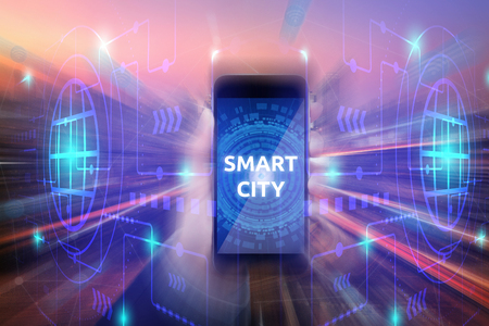 Business women show a smartphone with smart city on screen on technology background for internet of things technology and big data concept.の写真素材