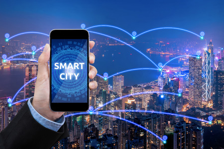 Business women show Smart city connection with smartphone over smart city communication network and internet of things for network communication concept.の写真素材