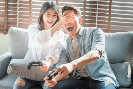 Asian couple lovers enjoy and play console game on vacation make more quality time of happiness together at homeの写真素材