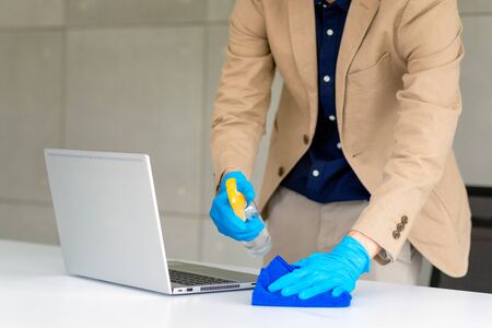 Business woman wearing mask and using personal sanitizer to cleaning his table in office to keep hygiene.Preventive during the period of epidemic from coronavirus or covid19.の写真素材
