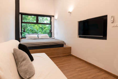 Bedroom with fresh nature green tree view through the window