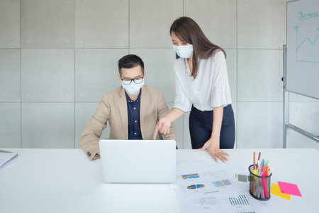 Business employees wearing mask during work in office to keep hygiene follow company policy.の写真素材