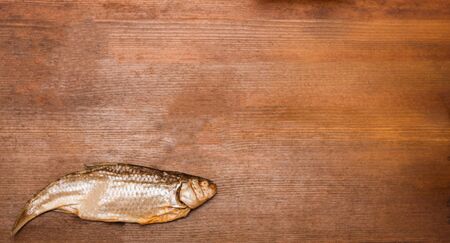 Dried fish on a wooden stained dark cherry tableの写真素材