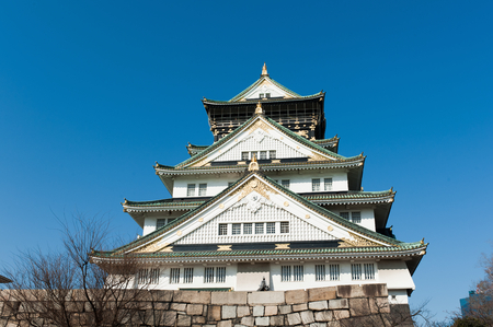 Osaka Castle with plum blossom trees in the foreground at the start of the Sakura in Japan.のeditorial素材