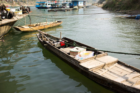 rowing boats for fishing and leisure moored at the side of a calm blue lakの写真素材