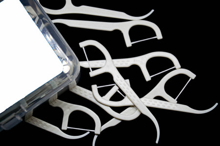 close up tooth picks and dental floss on a black backgroundの写真素材
