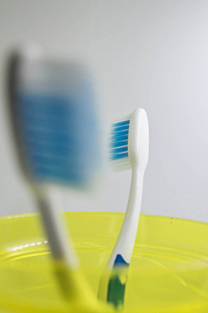 Close up  toothbrush in yellow glass on white background.の写真素材