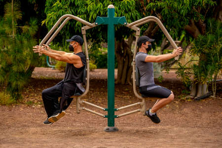 Men in the park with masks doing sport, machineの写真素材